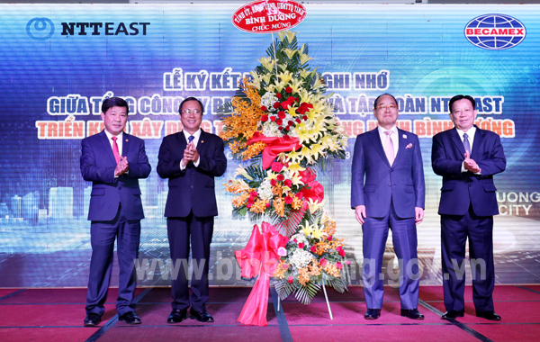 Ông Trần Văn Nam BTTU, ông Trần Thanh Liêm CTUBND tỉnh tặng lẵng hoa chúc mừng TCTYBecamex IDC và Tập.jpg